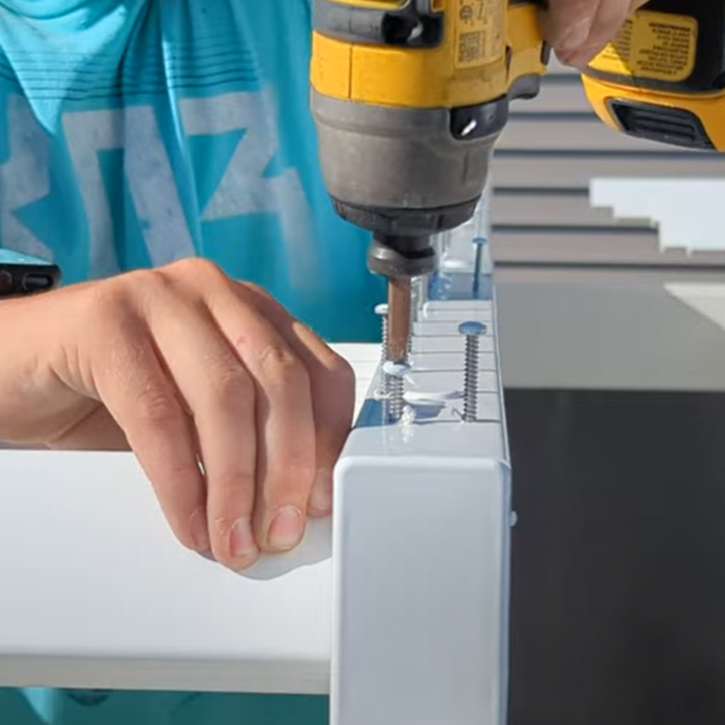 Person using a drill to assemble a Moda Pergolas.